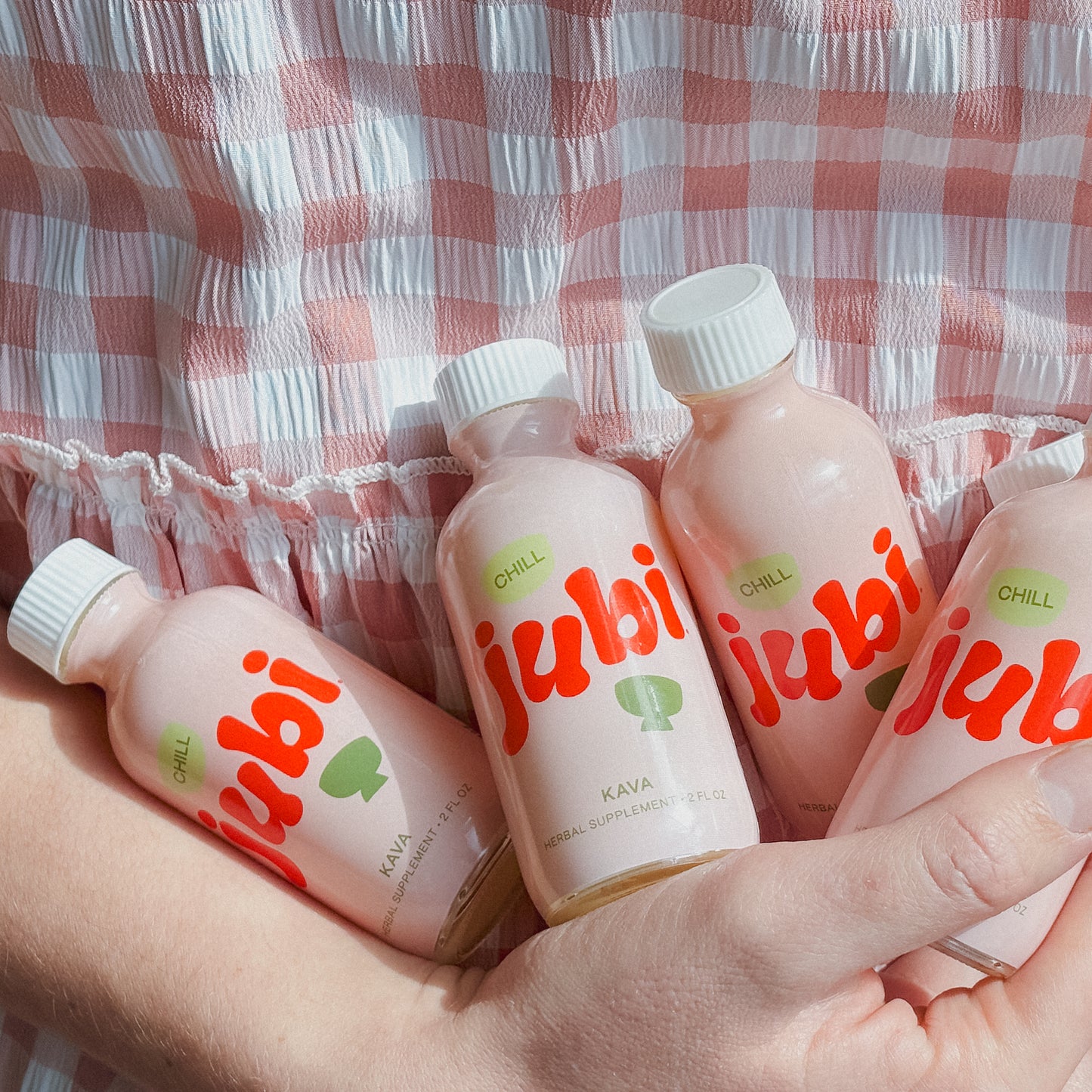 Hand holding Jubi Kava Chill Shots bottles.