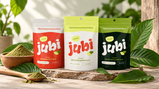 Three Jubi Maeng Da Kratom pouches in Red, White, and Green varieties displayed with kratom powder and fresh botanical leaves.